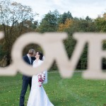 Brautpaar hinter einem Love Schild beim Brautpaarshooting in Brandenburg Fotografin Malag
