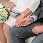 Brautpaar bei Trauung in Köpenick hält Händchen Fotografin Malag