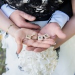 Brautpaar hält Hochzeitsringe auf Händen Love Buchstaben Malag